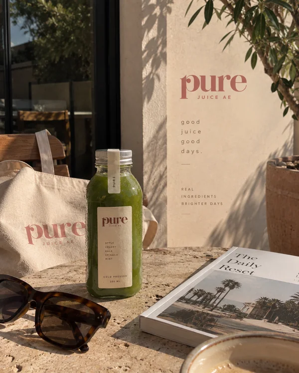Pure juice, a canvas tote and sunglasses in the afternoon sunlight